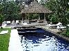 Bể bơi phong cách Bali được bao quanh bởi cỏ xanh, cây lá và được trang bị một khu lều nhỏ hay có cách gọi khác là vọng lâu ở một góc nào đó